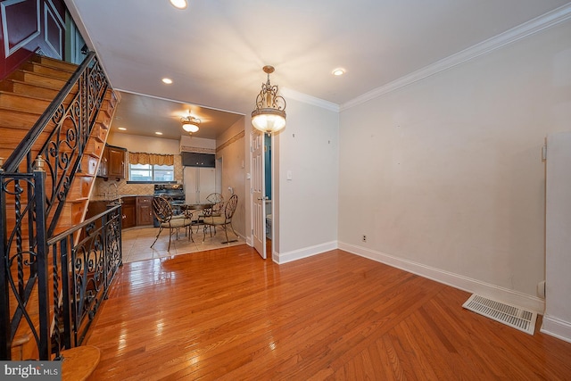 interior space featuring baseboards, light wood-type flooring, and visible vents