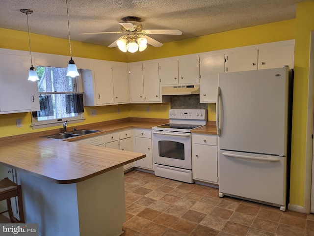 kitchen with a peninsula, white appliances, under cabinet range hood, white cabinets, and a sink