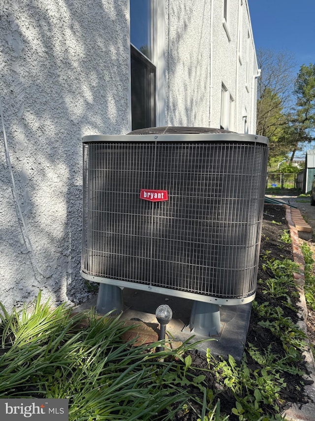 exterior details featuring central AC unit and stucco siding