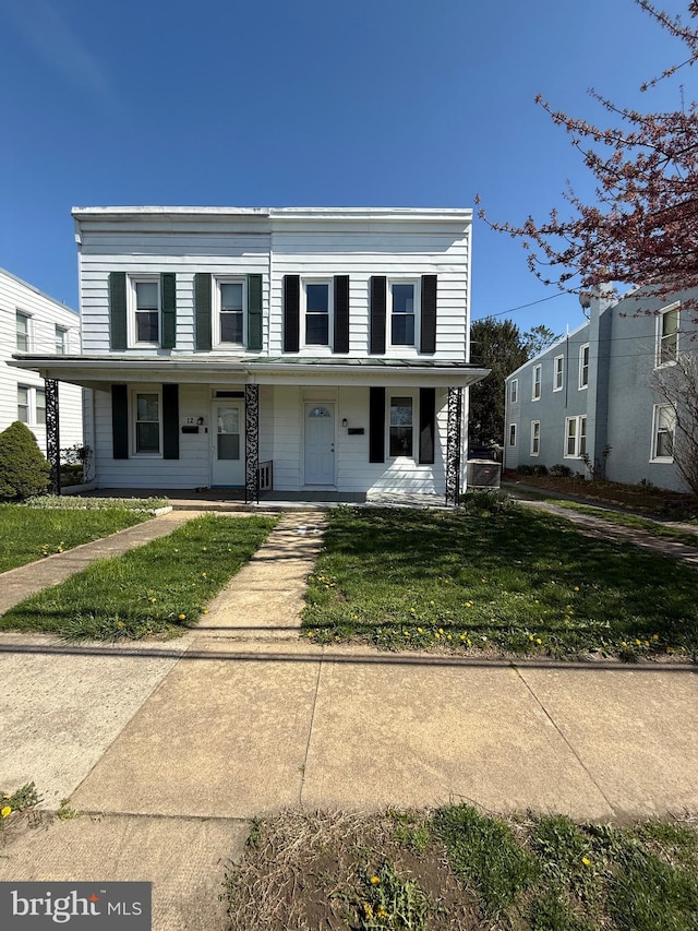 view of front facade featuring covered porch and a front yard