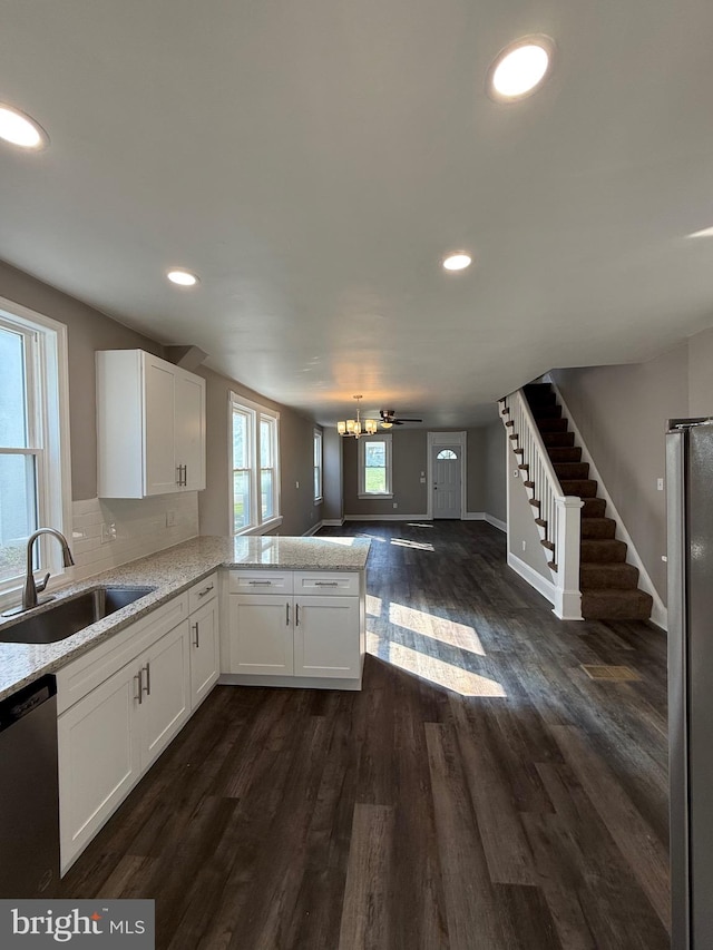 kitchen featuring recessed lighting, a sink, white cabinetry, and open floor plan