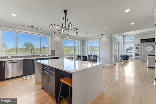 kitchen featuring a kitchen island, dishwasher, a sink, open floor plan, and recessed lighting