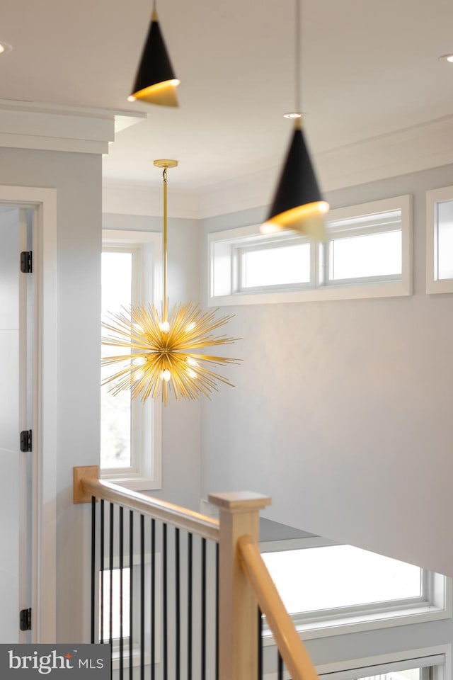 hall with crown molding, an upstairs landing, and an inviting chandelier