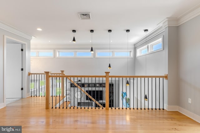 hallway featuring baseboards, an upstairs landing, wood finished floors, and visible vents