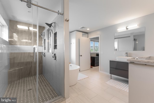 full bath with visible vents, a freestanding tub, vanity, and a shower stall