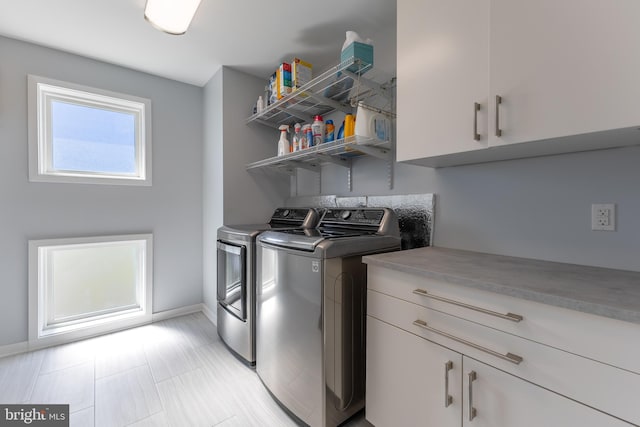 laundry room featuring baseboards, cabinet space, and washing machine and dryer