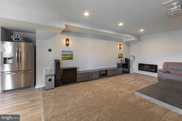 living area with recessed lighting, baseboards, and a glass covered fireplace