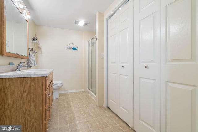 bathroom with visible vents, a stall shower, baseboards, vanity, and toilet