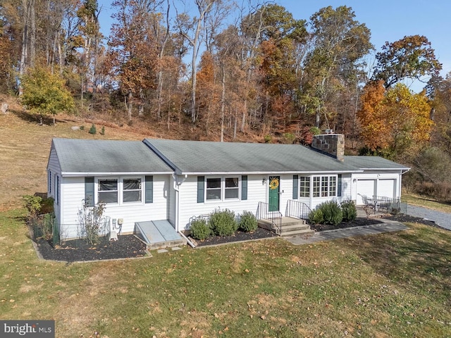 single story home featuring roof with shingles, a chimney, an attached garage, and a front lawn