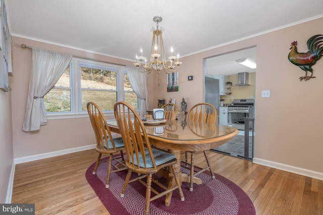 dining space featuring crown molding, baseboards, an inviting chandelier, and light wood-type flooring