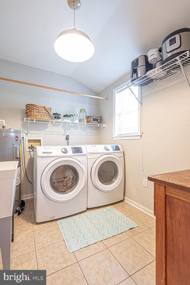 laundry area with laundry area, light tile patterned floors, washing machine and dryer, and electric water heater
