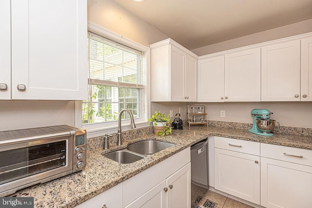 kitchen featuring a toaster, white cabinetry, light stone counters, a sink, and dishwasher