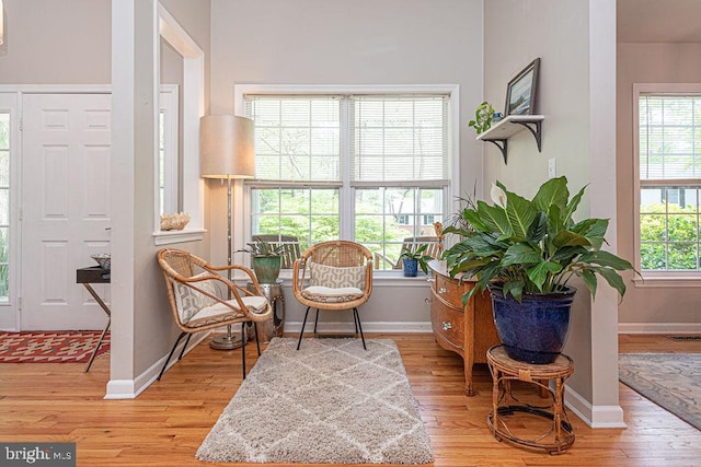 sitting room featuring baseboards, light wood finished floors, and visible vents