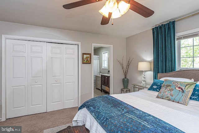 bedroom featuring carpet flooring, ceiling fan, ensuite bath, and a closet