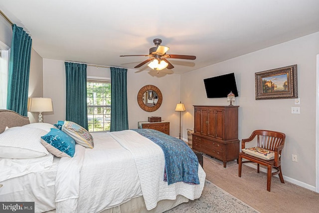 bedroom featuring baseboards, light carpet, and ceiling fan
