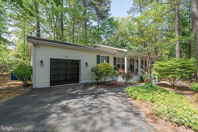 view of front facade with a porch, an attached garage, and driveway