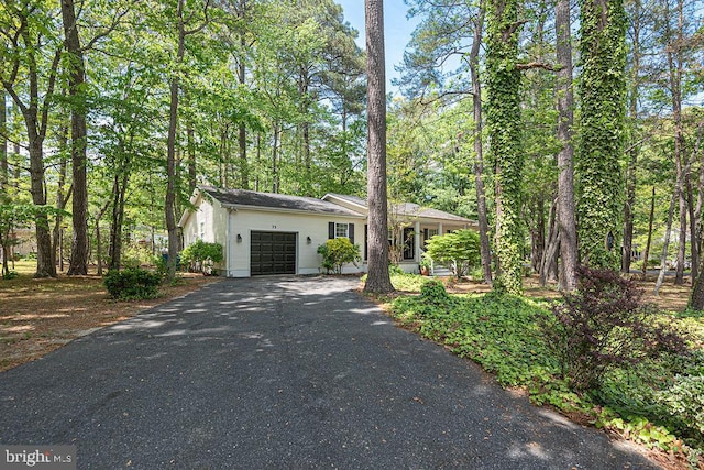 view of front of home with aphalt driveway and a garage