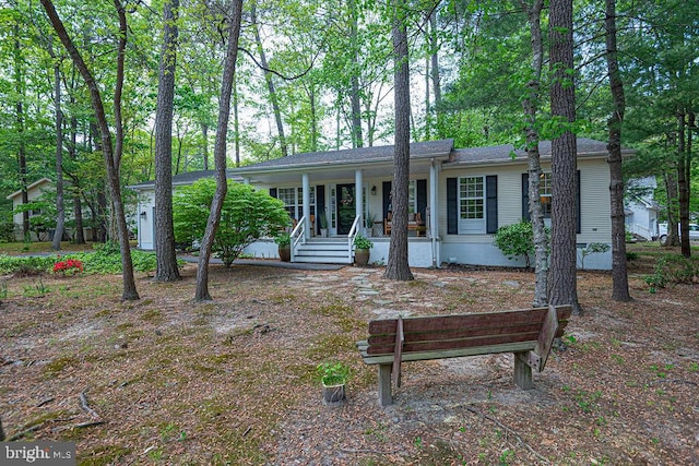 single story home featuring covered porch and roof with shingles