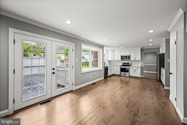 unfurnished living room featuring ornamental molding, french doors, baseboards, dark wood-style floors, and recessed lighting