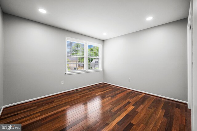 unfurnished room with dark wood-style flooring and recessed lighting