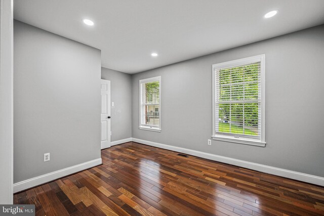 unfurnished room featuring baseboards, hardwood / wood-style floors, and recessed lighting