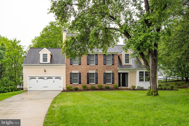 colonial home with concrete driveway, a chimney, a garage, and roof with shingles