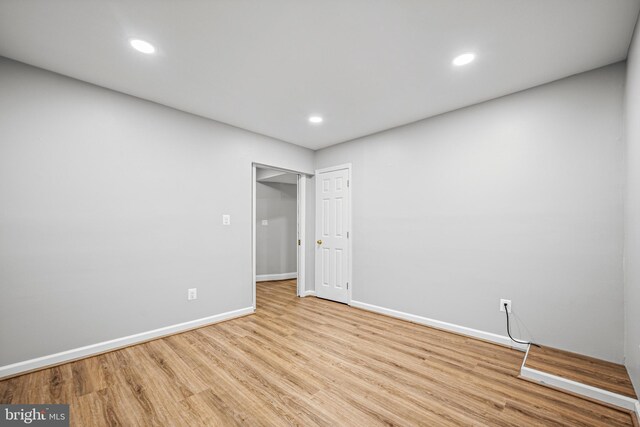 spare room featuring baseboards, wood finished floors, and recessed lighting