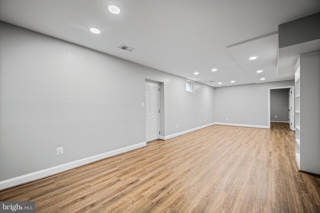 finished basement with light wood-style flooring, baseboards, and recessed lighting