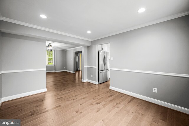 empty room with crown molding, baseboards, wood finished floors, and recessed lighting