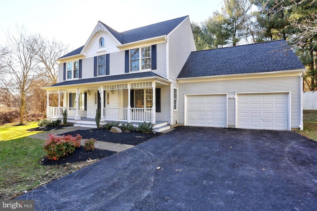 view of front of home featuring roof with shingles, an attached garage, a front lawn, covered porch, and driveway
