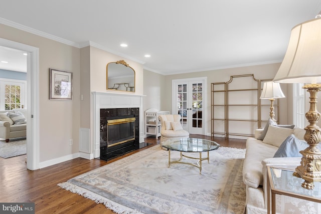 living area featuring a healthy amount of sunlight, recessed lighting, wood finished floors, and a premium fireplace