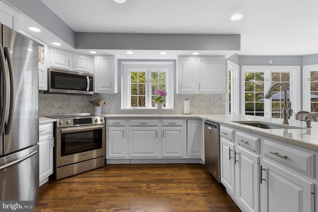 kitchen with a sink, appliances with stainless steel finishes, recessed lighting, and white cabinetry