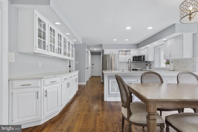kitchen featuring glass insert cabinets, recessed lighting, white cabinets, dark wood finished floors, and stainless steel appliances