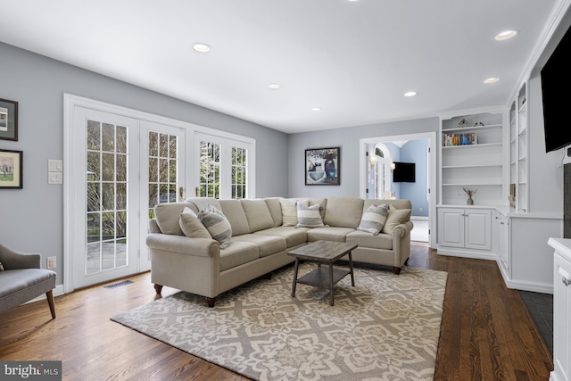 living room featuring dark wood-style flooring, recessed lighting, baseboards, and visible vents