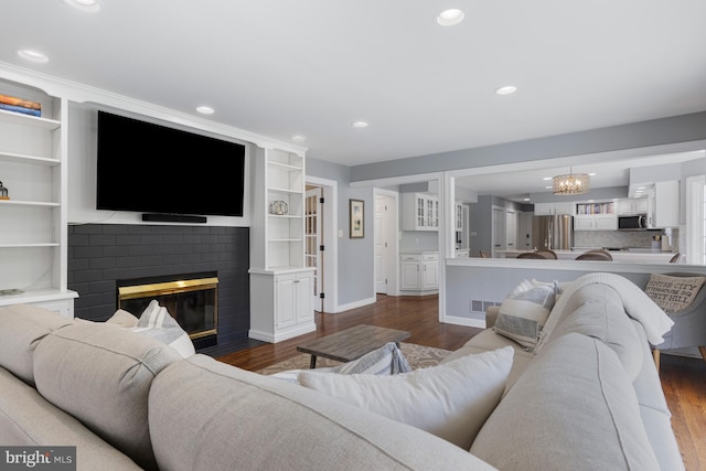 living room with baseboards, recessed lighting, dark wood-style flooring, and a brick fireplace