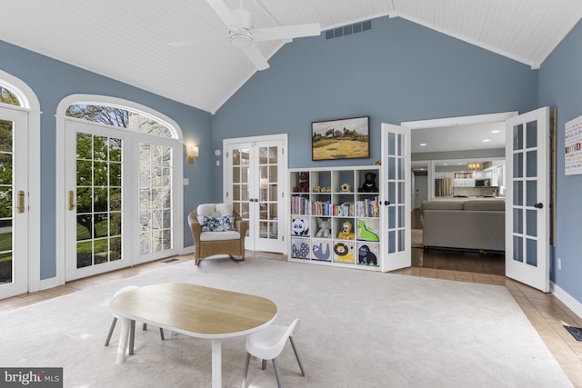 sitting room with ceiling fan, french doors, visible vents, tile patterned flooring, and high vaulted ceiling