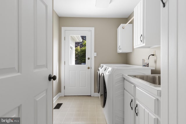 laundry area with cabinet space, a sink, baseboards, visible vents, and washer and clothes dryer
