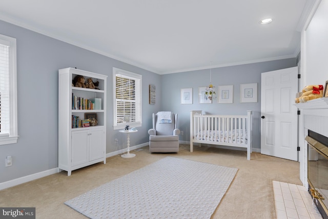 bedroom featuring baseboards, ornamental molding, a fireplace, and light carpet