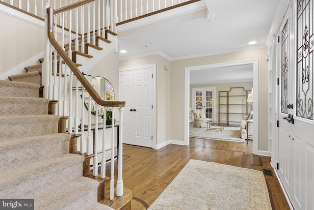 entryway with crown molding, stairs, wood finished floors, baseboards, and recessed lighting