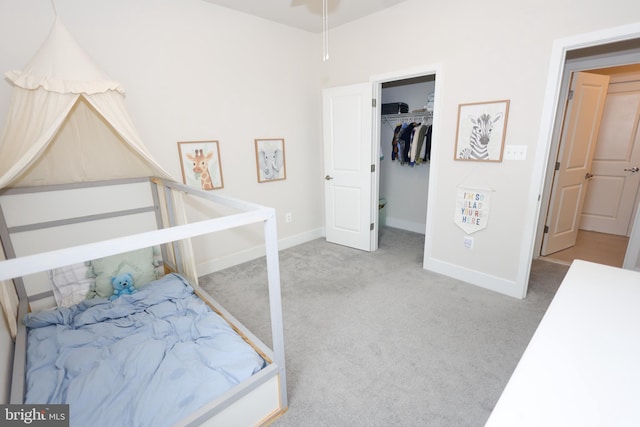 bedroom featuring carpet flooring, baseboards, and a spacious closet
