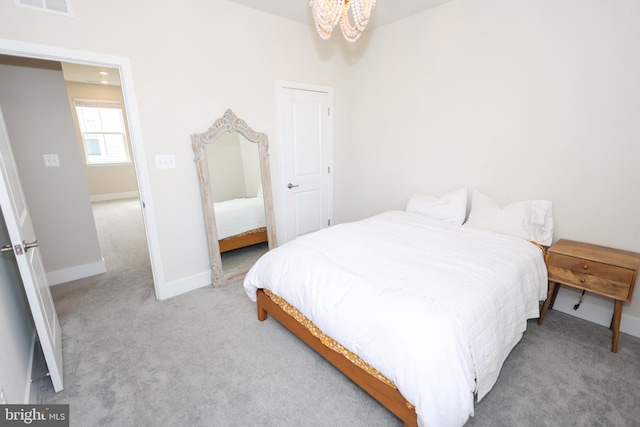 bedroom featuring a chandelier, carpet, and baseboards