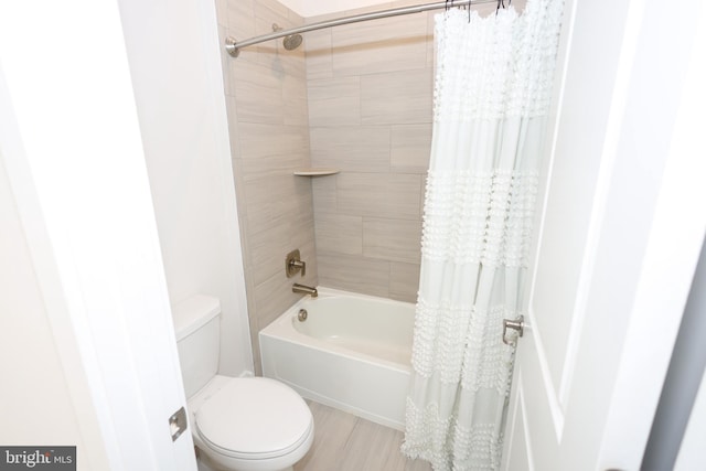 bathroom featuring toilet, shower / bath combo, and wood finished floors