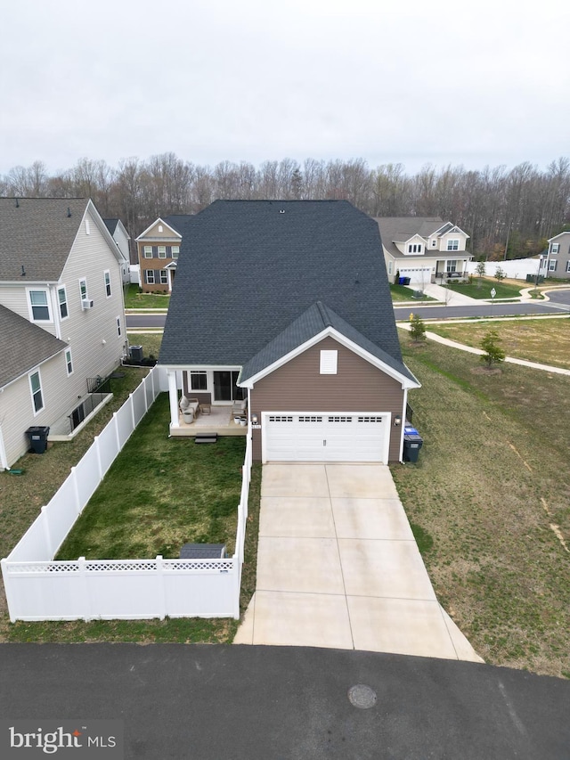 view of front facade with driveway, a residential view, an attached garage, and roof with shingles