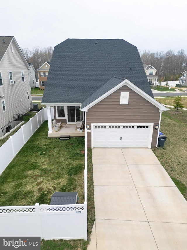 view of front facade with concrete driveway, roof with shingles, a garage, and a deck