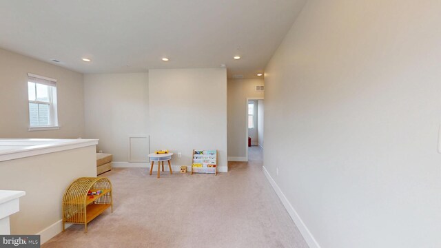 recreation room with healthy amount of natural light, recessed lighting, light colored carpet, and baseboards