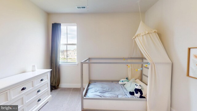 bedroom with light colored carpet and baseboards