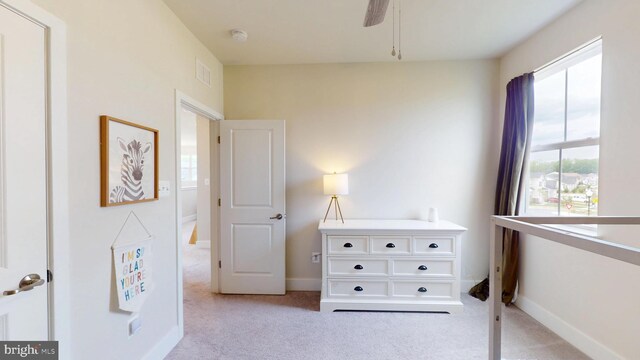 bedroom with light carpet, baseboards, and a ceiling fan