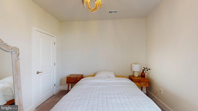 bedroom with a chandelier, carpet flooring, and baseboards