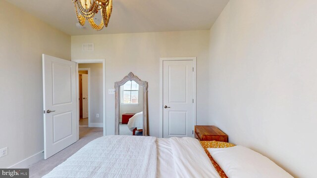 bedroom with a chandelier, light colored carpet, and baseboards