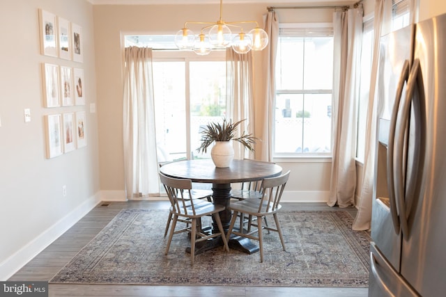 dining space featuring a chandelier, baseboards, and dark wood-style floors